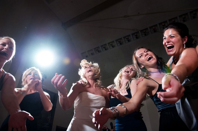 A group of bridesmaids dance together during a wedding reception at the Omni William Penn Hotel in Pittsburgh, Pennsylvania.